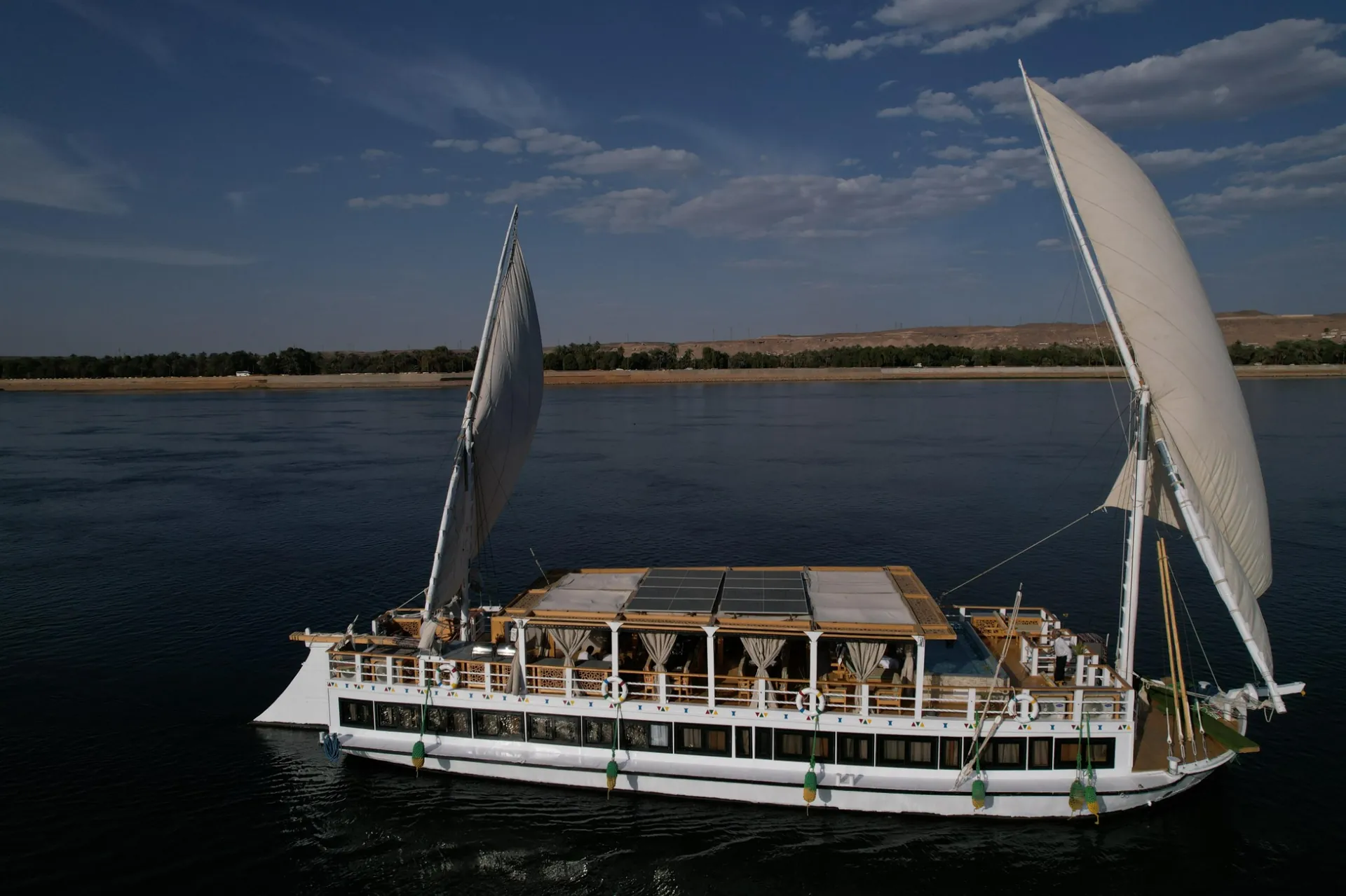 Dahabeya sailing boat under full white sail on the Nile